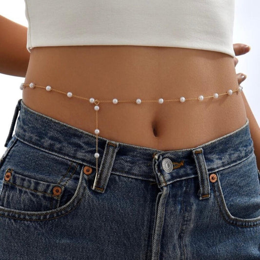 Pearl waist chain worn by a person with a white top and blue jeans.