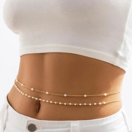Gold chain belt with pearls worn by a person on a white background