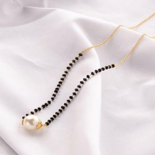 Pearl mangalsutra necklace on a white fabric background
