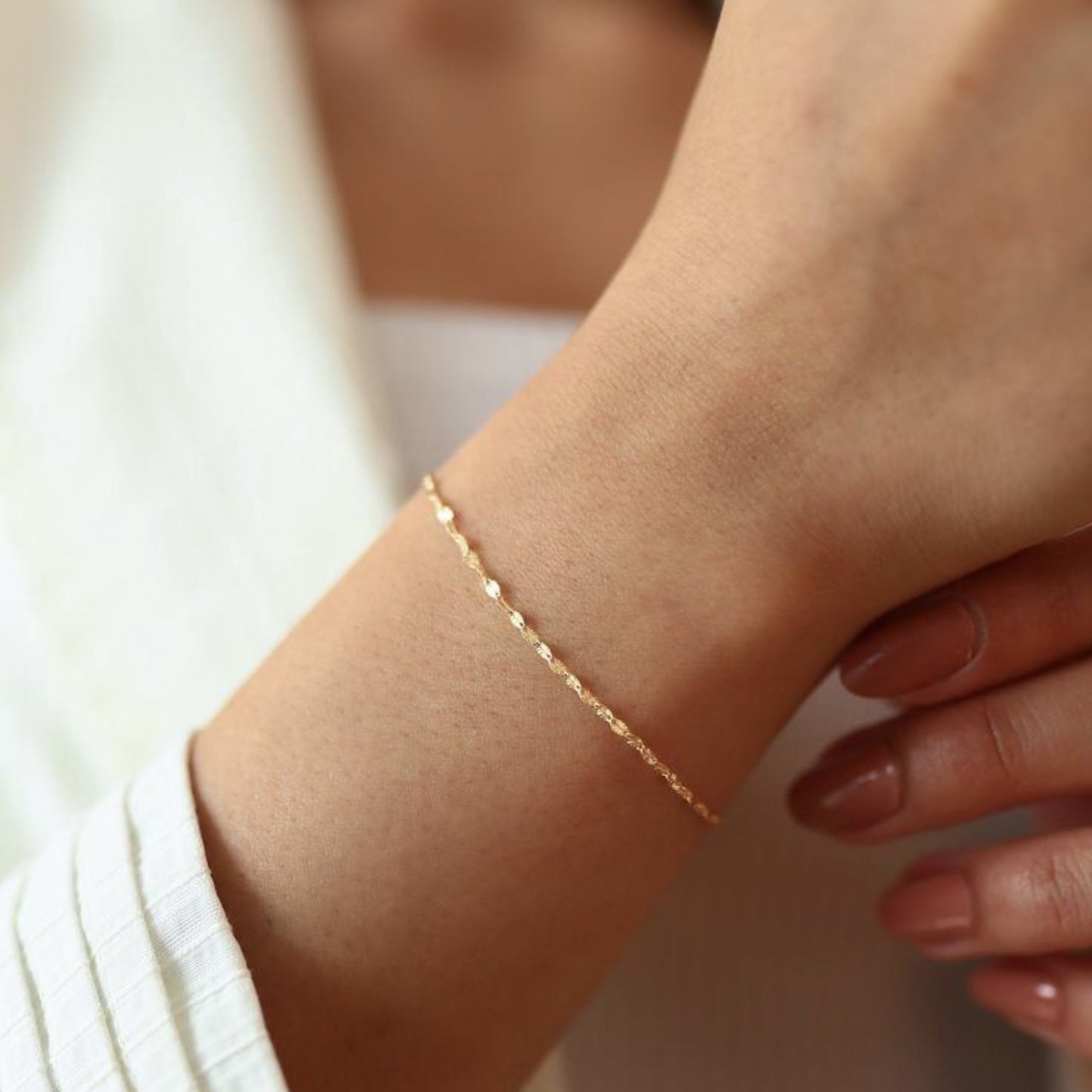 Gold bracelet on a wrist with a blurred background