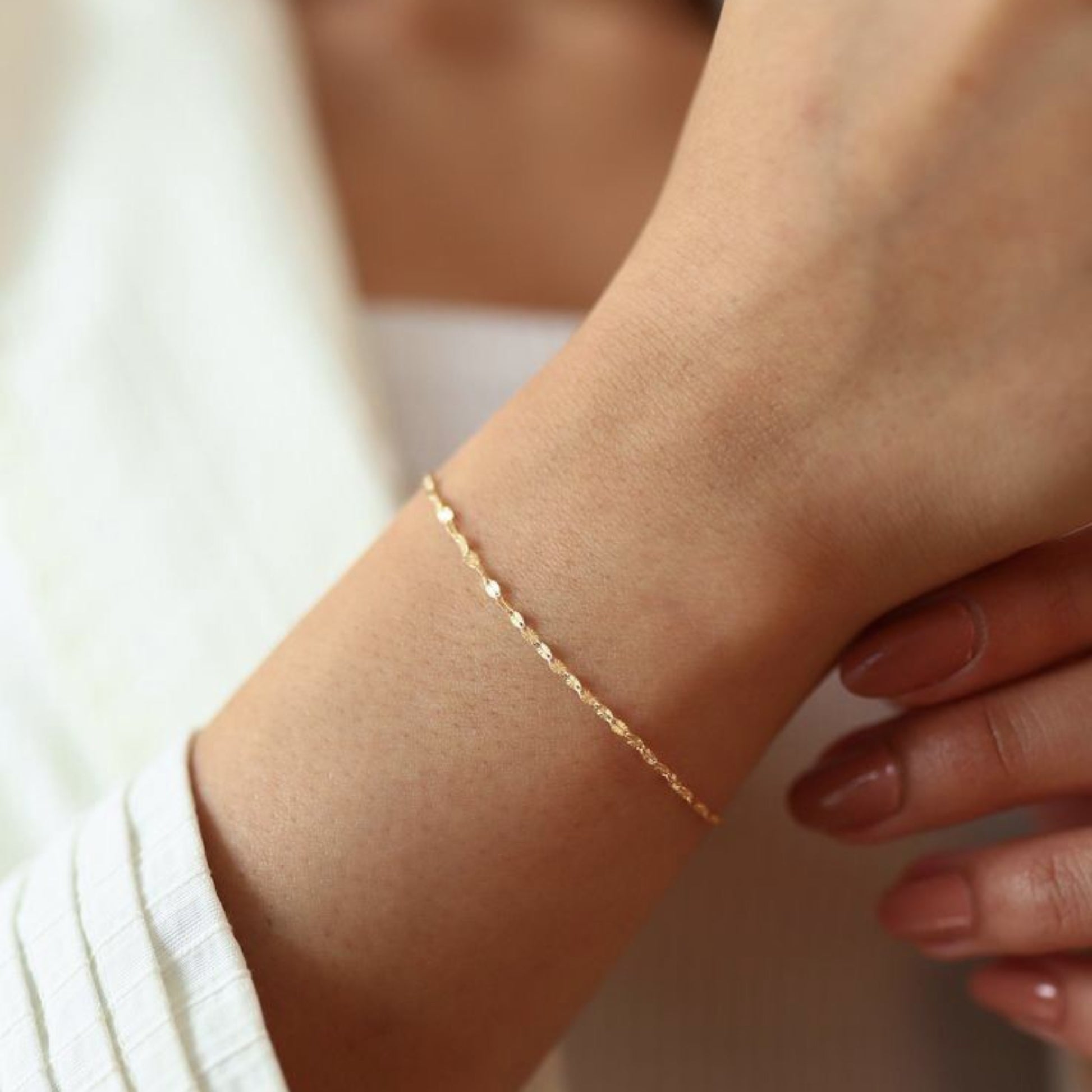 Gold bracelet on a wrist with a blurred background