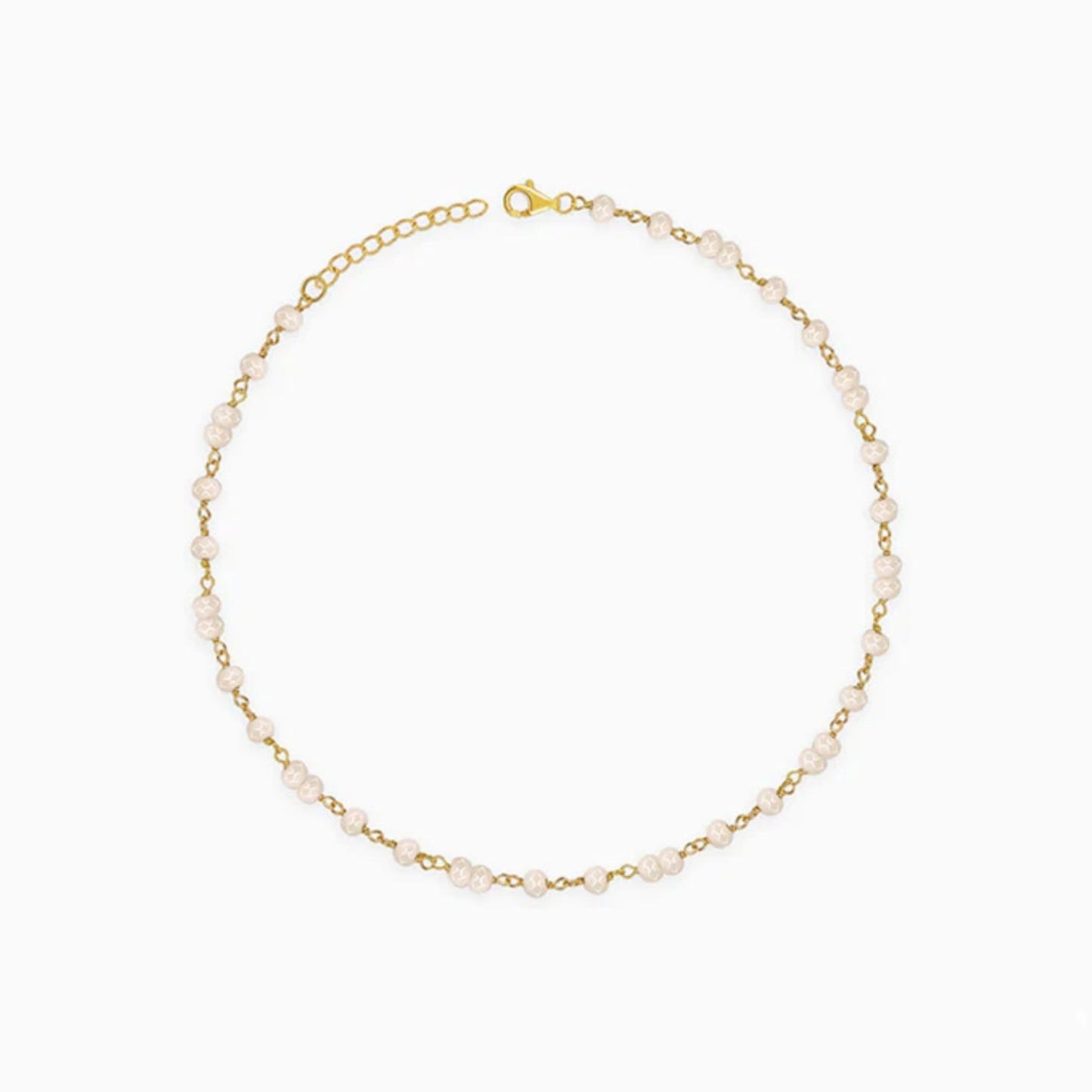 Gold bracelet with small pearls on a white background