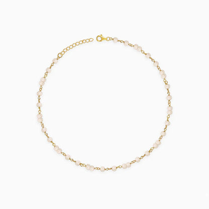 Gold bracelet with small pearls on a white background